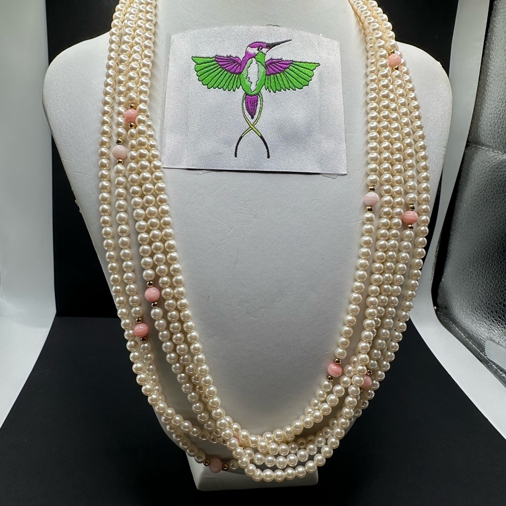 Vintage multi layer pearl necklace with occasional pink embellishments.